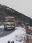 SX12145 Gritting truck driving through hillsides covered in snow.jpg